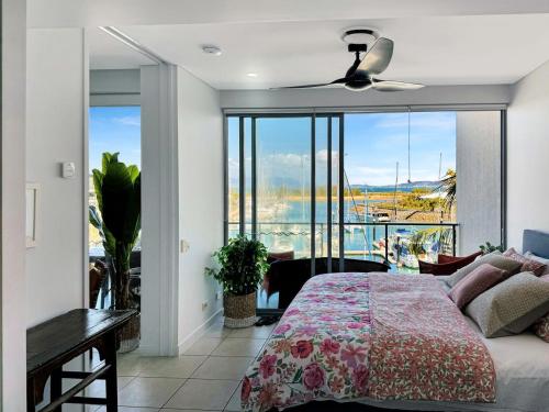a bedroom with a bed and a view of the ocean at Blue on Blue Apartment 933 in Nelly Bay