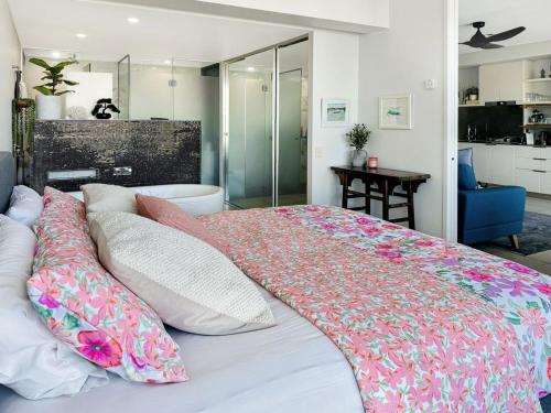 a bedroom with a large bed with pillows on it at Blue on Blue Apartment 933 in Nelly Bay