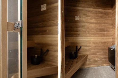 a sauna with black pots in a wooden wall at Twintip Apartments in Åre