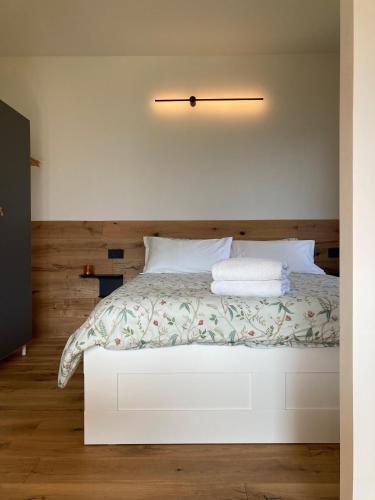 a bedroom with a white bed with a wooden headboard at Lake Retreat in Anfo