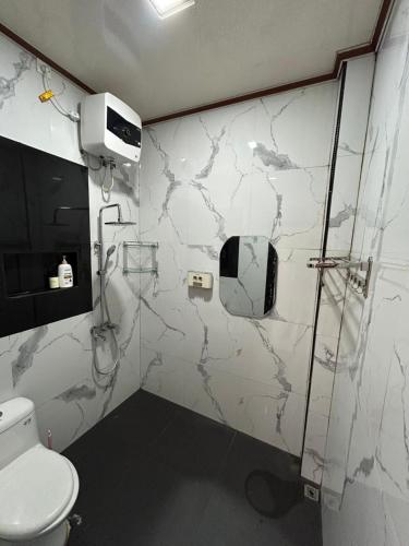 a bathroom with a toilet and a shower in it at Livi Guest House in Sekupang