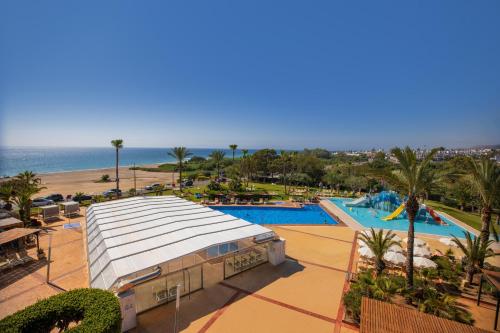 Blick auf ein Resort mit Swimmingpool und dem Meer in der Unterkunft Hotel Servigroup Marina Playa in Mojácar