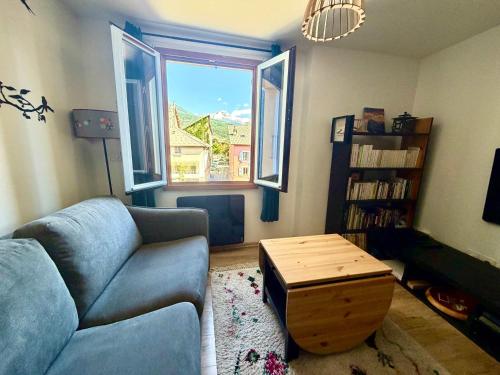 a living room with a couch and a table at Appartement cocooning centre ville in Embrun