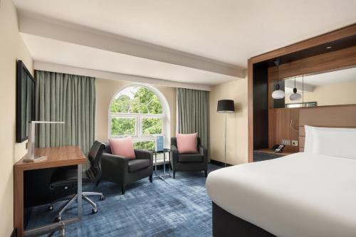 a hotel room with a bed and a desk and chair at Crowne Plaza Gerrards Cross by IHG in Beaconsfield