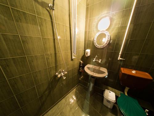 a small bathroom with a sink and a mirror at Serdika Rooms in Sofia
