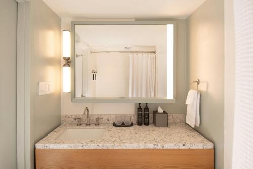 a bathroom with a sink and a mirror at Marin Hilltop Hotel in San Rafael