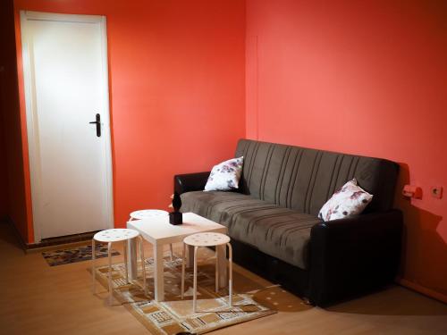 a living room with a black couch and a red wall at Serdika Rooms in Sofia