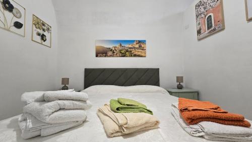 a bedroom with a bed with towels on it at Casa Alba in Bernalda
