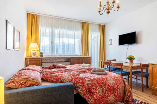 a bedroom with a bed and a dining room at Grimmingblick Apartment mit Pool in Reith