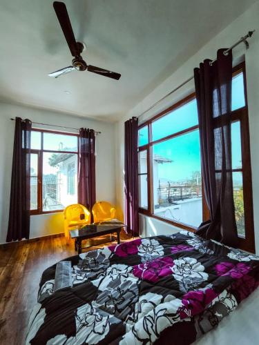 a bedroom with a bed and a large window at North Sky Stays Bir in Bīr