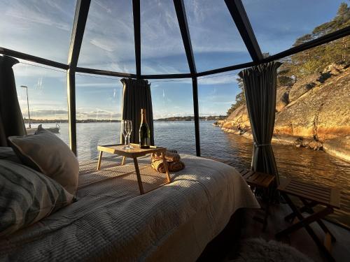a bedroom with a bed and a view of the water at Stockholm Archipelago Igloo Hut in Tynningö