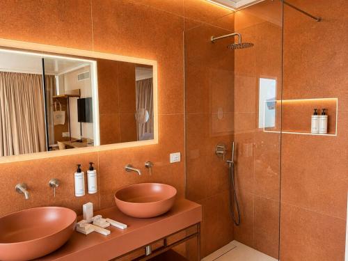 a bathroom with two sinks and a glass shower at Beach Hotel Terracotta in Sapri