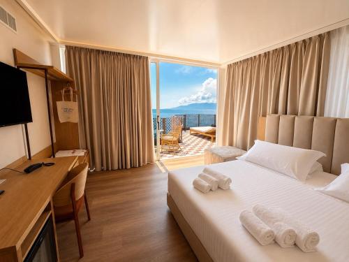 a hotel room with a bed and a desk with towels at Beach Hotel Terracotta in Sapri