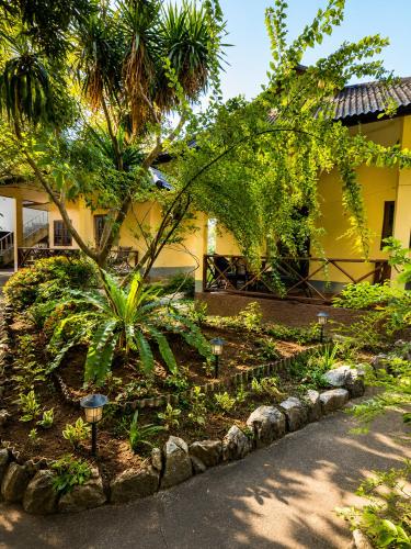 a garden in front of a yellow building at Röstiland by NOXAMA SAMUI in Lamai
