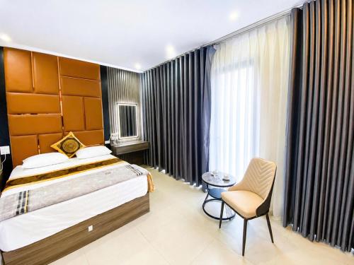 a bedroom with a bed and a chair in a room at Nhà Nghỉ Lacasta Hotel in Văn La
