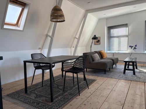 a living room with a table and chairs and a couch at Logement Hoogend in Sneek