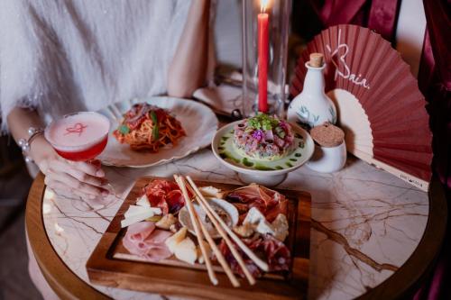 a table with a plate of food and chopsticks at Pipa Bangkok Sukhumvit 11 by Kingston Hotels in Bangkok