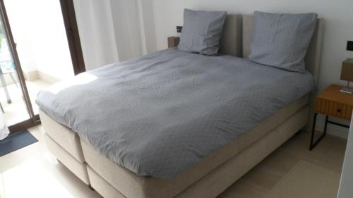 a large bed in a bedroom with a night stand at Villa Ceesito in Los Alcázares