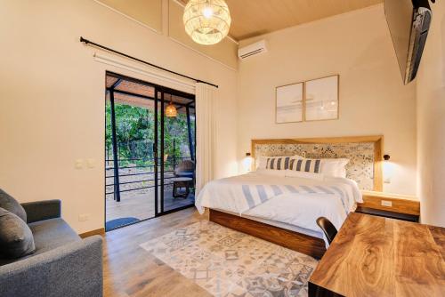 a bedroom with a bed and a table and a couch at Casa AMALFI Pool House Playa Neg in Puerto Viejo
