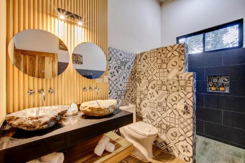 a bathroom with a sink and a toilet and a mirror at Casa AMALFI Pool House Playa Neg in Puerto Viejo