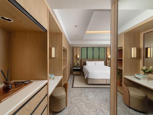 a hotel room with a bed and a desk at Samala Suites Bangkok Sukhumvit 19 by Kingston Hotels in Bangkok