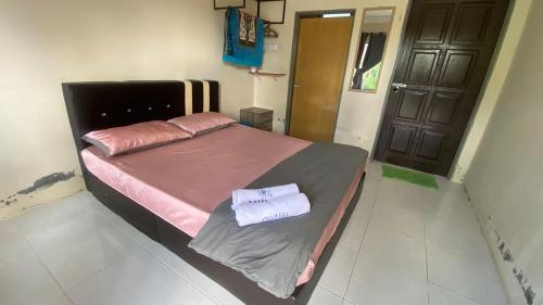 a bedroom with a bed with two towels on it at Hotel O D Mama Chalet in Jeniang