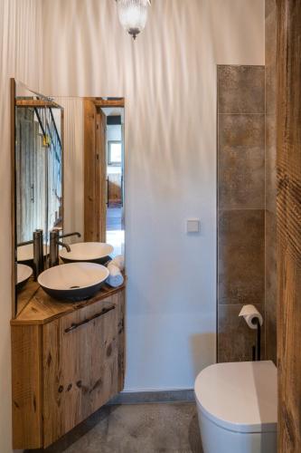 a bathroom with two sinks and a tub and a toilet at steiRerBLiCke - Weinstöckl Steinbach in Steinbach
