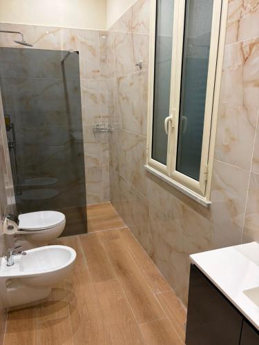 a bathroom with a toilet and a sink and a shower at Domus Rhegium in Reggio di Calabria