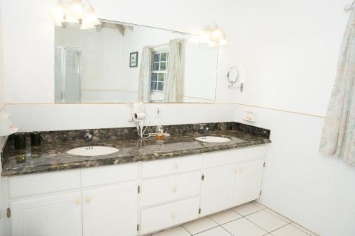 a bathroom with two sinks and a mirror at Oualie Beach Resort in Nevis