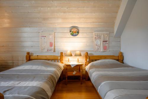 a room with three beds and a table with a lamp at Chambres d'hôtes, Les Combes in Orbey