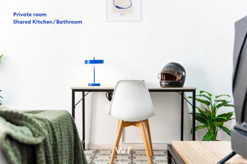 a desk with a white chair in a living room at weroomies - Pons Icar H3 in Tarragona