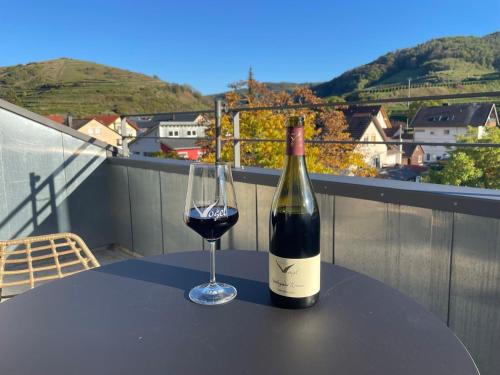 a bottle of wine sitting on a table with a glass at Apartment Steinkauz in Vogtsburg