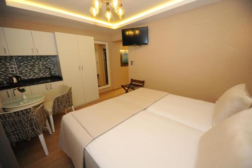 イスタンブールにあるRooms Inn Taximのベッドルーム(大きな白いベッド1台付)、キッチンが備わります。