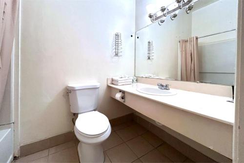 a bathroom with a toilet and a sink and a mirror at Carquinez Inn Vallejo I 80 Near Napa Valley in Vallejo