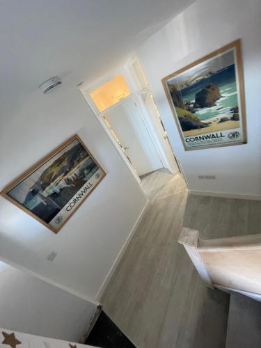 a hallway with two pictures on the walls of a building at 1 Marine House in Penzance