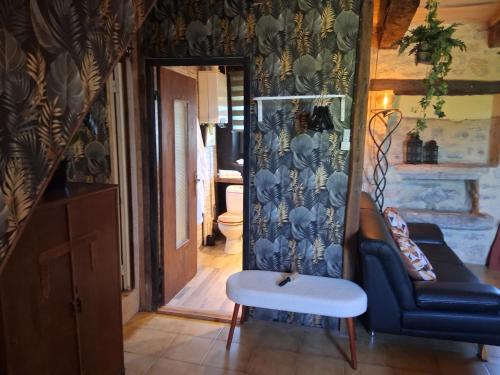 a living room with a couch and a stool at B&B maison du Saint Cirque in Saint-Dau