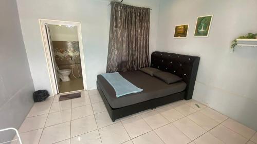 a small bed in a room with a mirror at Hotel O D Longan Cottage in Kampung Tikam Batu