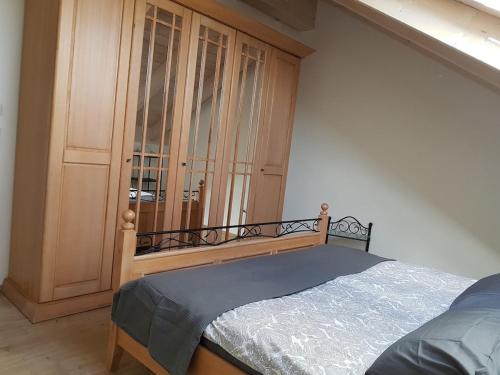 a bedroom with a bed and a wooden cabinet at Double room 75 sqm between Augsburg and Munich in Wiedergeltingen