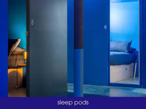a blue room with a mirror and a bed at NQnap in Manchester