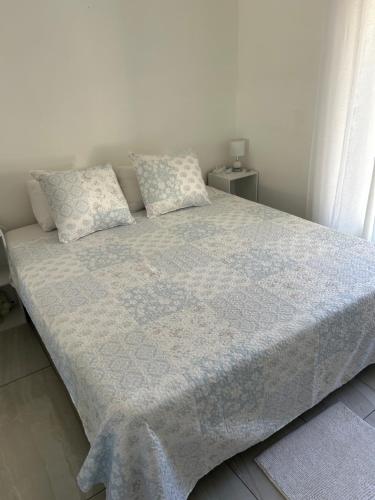 a bed with a blue blanket and pillows on it at Chez Ava in Salazie