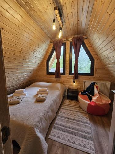 a bedroom with a bed in a wooden cabin at Plai cu dor - Brebu in Brebu Mînăstirei