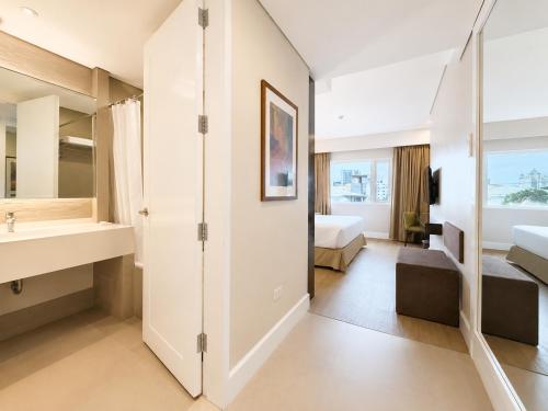 a hotel room with a sink and a bathroom at Harolds Hotel Cebu in Cebu City