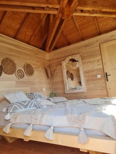 a bedroom with a large bed in a wooden wall at L'écureuil perché in Apt