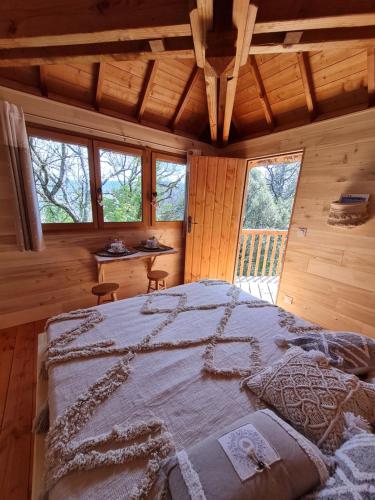 a bedroom with a large bed in a cabin at L'écureuil perché in Apt
