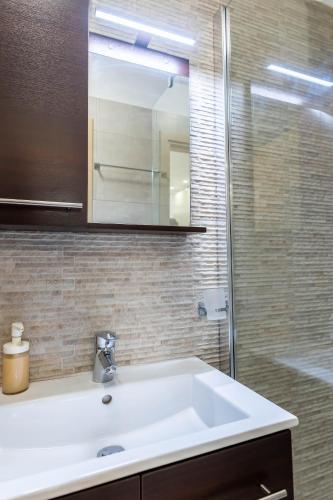 a bathroom with a white sink and a shower at Alex port view apartments in Syvota