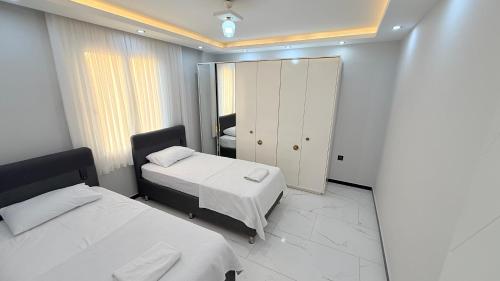 a bedroom with two beds and a mirror at Villa Guru Efeler in Didim