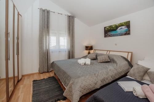 a bedroom with a bed with two stuffed animals on it at Apartmani Saric A&K in Vir