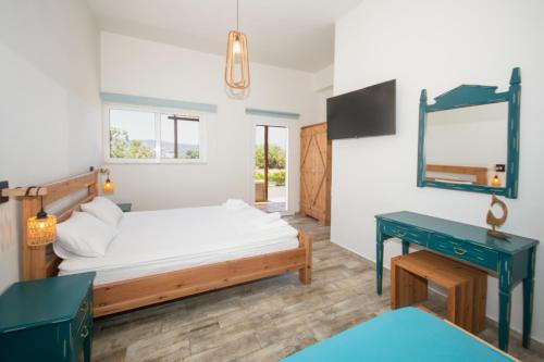 a bedroom with a bed and a desk and a mirror at Naya in Kissamos