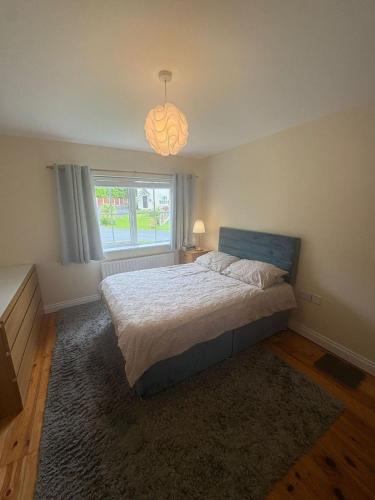 a bedroom with a large bed and a window at The Cloverhill House in Mullaghbane