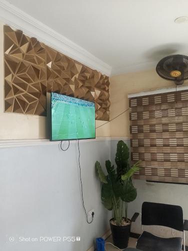 a flat screen tv on a wall in a living room at Extramile Hotel and Lounge in Ibadan